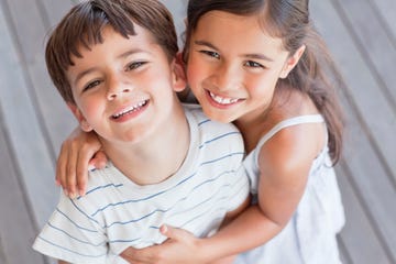 portrait of brother and sister hugging and smiling