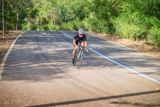 young man cyclist riding mountain bike in public park at moring