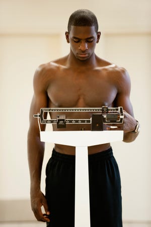 Young man standing on weight scale