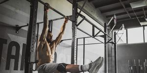 young muscular build athlete exercising strength in a gym