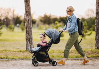 mãe andando com a filha no carrinho