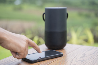 mão conectando caixa de som ao celular