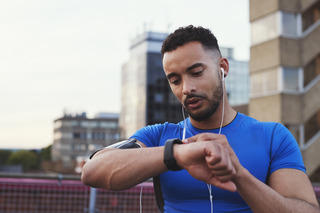 Homem checa o smartwatch antes de iniciar o exercício