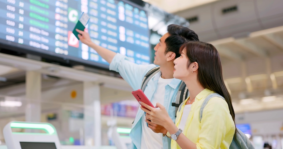 PHOTO: Stock photo of a couple looking at plane departure times.