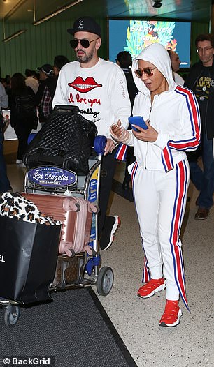 Helping hand: Mel was joined by her close pal Gary Madatyan, who helped out the star by pushing her luggage through the airport as they made their exit