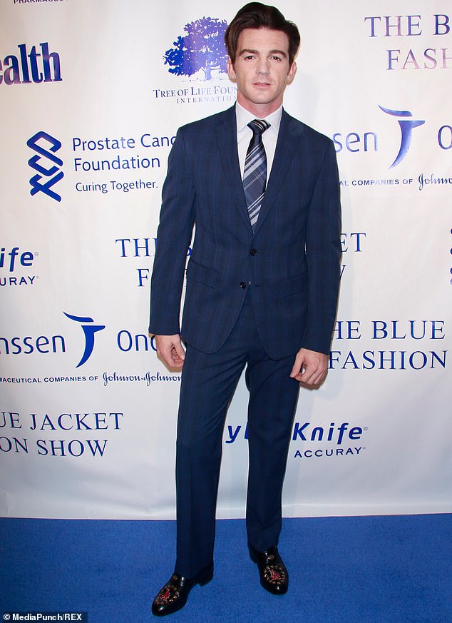 Smoldering stare: Drake Bell cut a hunky figure in a blue checked suit, popping on a blue and silver striped tie and adding a splash of contrast with red and black shoes