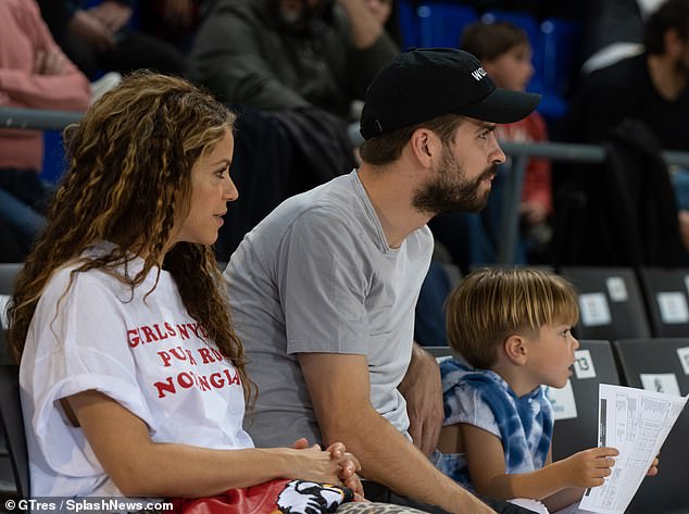 Happy families: Cute little Milan sat beside dad for part of the basketball game