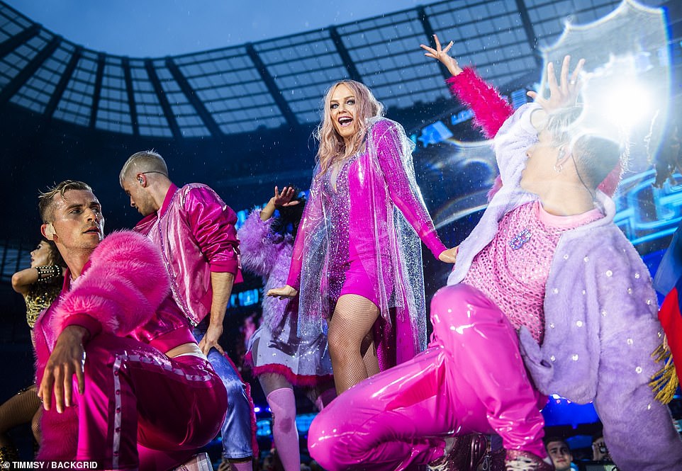 Restrained: Emma kept her performance much more PC as she teetered on heels whilst surrounded by dancers