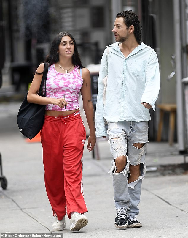 Happy day: After doing some browsing inside a store, she stepped back out on to the street with her male pal, enjoying a smoke from her vape pen