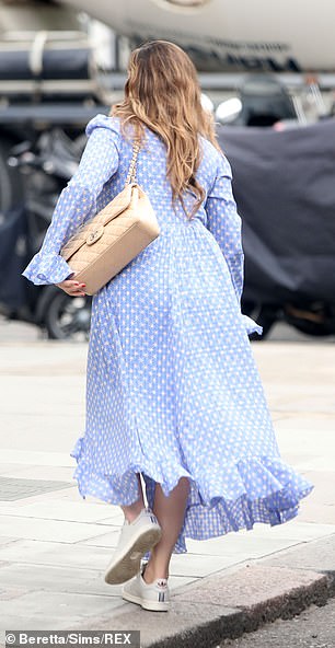 Elegant: Showcasing her hourglass curves, the model donned a cornflower blue dress that cinched in at her tiny waist before flaring out in an ankle-length skirt