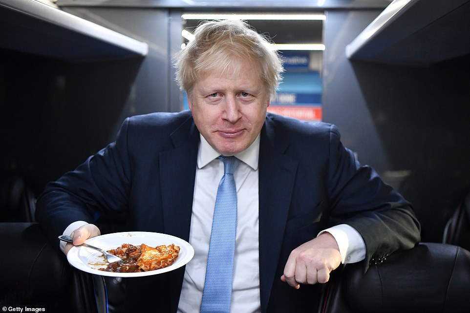 Boris Johnson eats a portion of pie on the campaign bus after a visit to the Red Olive catering company on the final day of campaigning in Derby
