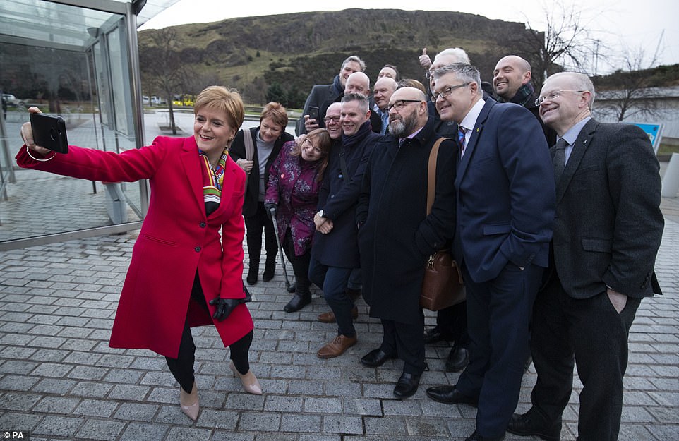 Nicola Sturgeon was fulfilling her first ministerial duties at the Scottish Parliament today, posing for a picture with SNP supporters afterwards