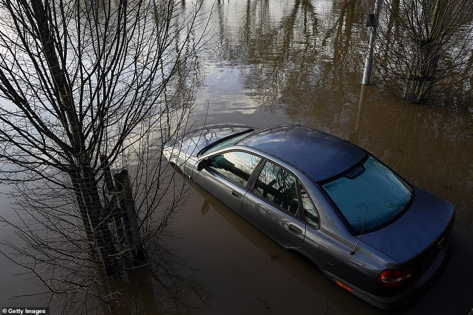 A car is stranded in a car park as the waters of the River Ouse passing through York breach the river banks causing flooding as water levels rise