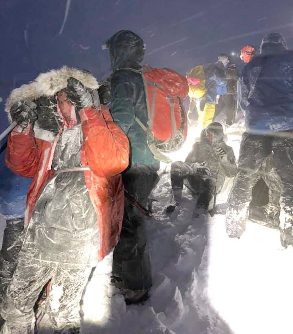 The 'stupid' quartet (one walker pictured sitting down) became trapped near the 4,413ft-high summit in the Scottish Highlands after embarking upon a walk up Ben Nevis during freezing 80mph winds