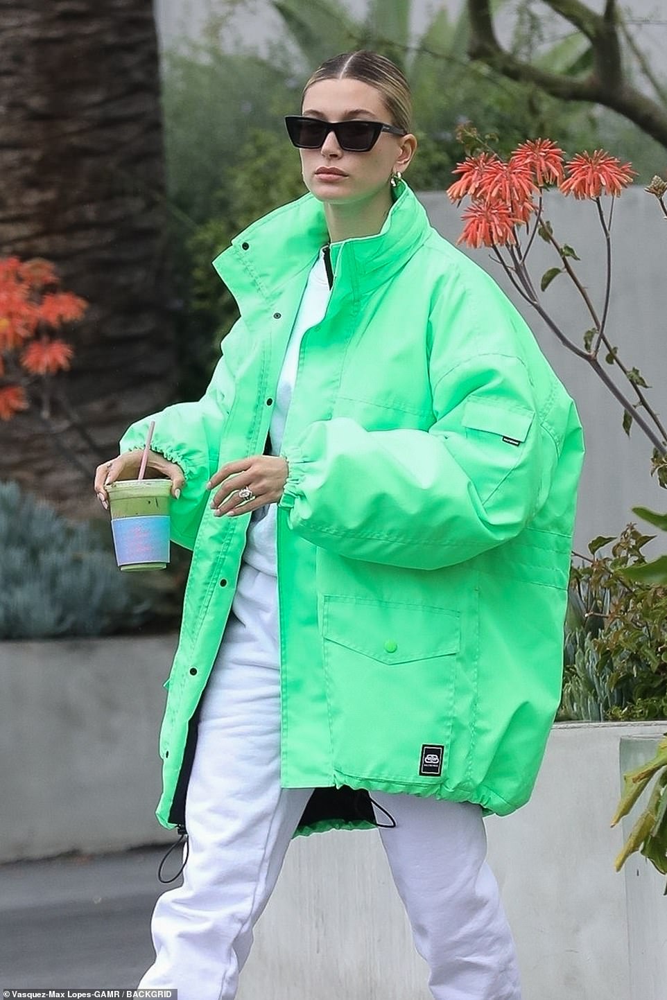 Going green: She switched out her black coat and opted for a rainproof oversized neon jacket