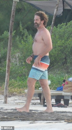 Beach hunk: Gerard looked every inch the movie star during his trip down the beach