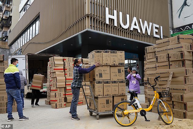 Rebound: Workers move boxes of computers on a street in Wuhan on Saturday, after Chinese companies and exporters took advantage of the global economic standstill