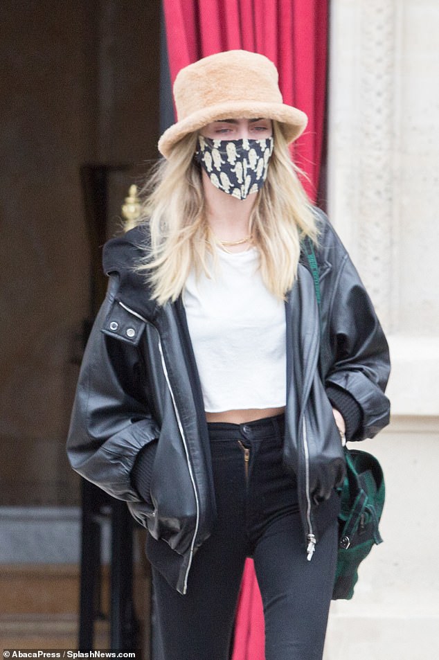 Style in the city: She flashed a hint of skin with her cropped white t-shirt and added a patterned face mask