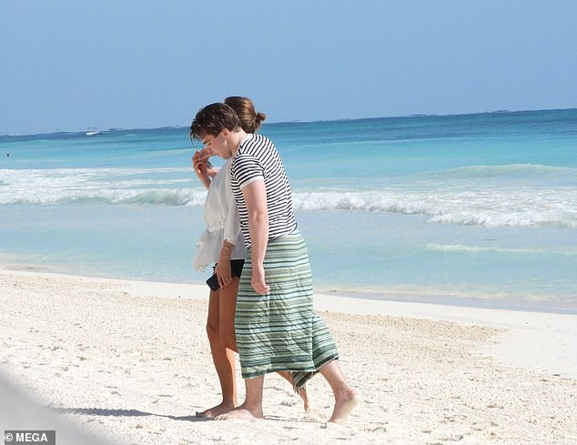 Romantic: The pair were spotted walking along the shore with their hands interlinked