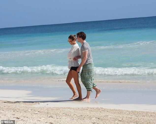 In good company: They chatted away as they strolled along the sandy shore