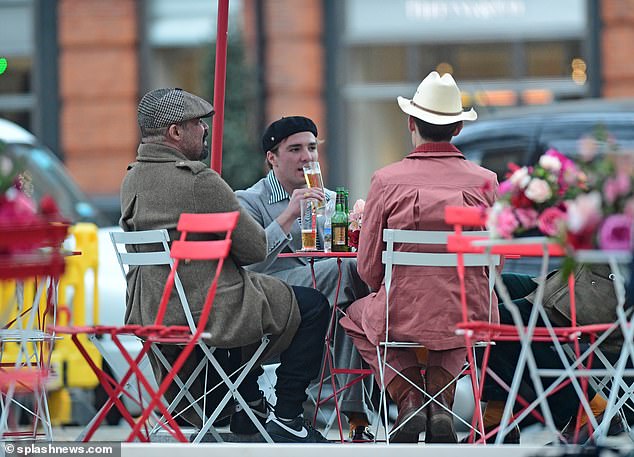 Pals: Ritchie sipped on a pint of beer as he sat in the bar with two of his close friends