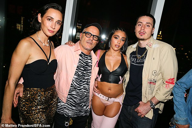 Posing with Rebecca Dayan and Giovanni Bianco: The model and dancer wowed in a black leather zip-up bra top, along with pink crotchless chaps and matching fuzzy thong panties