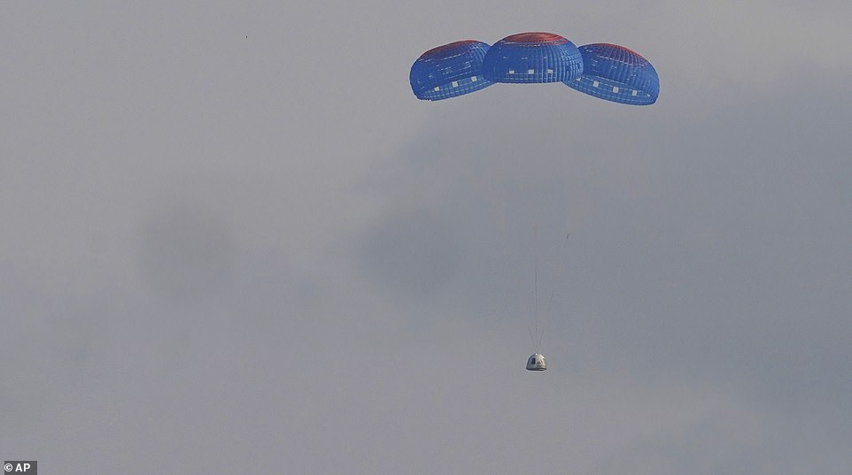 Jeff Bezos and the rest of crew Blue Origin return to earth in their capsule as it descends with three blue parachutes slowing its pace on Tuesday