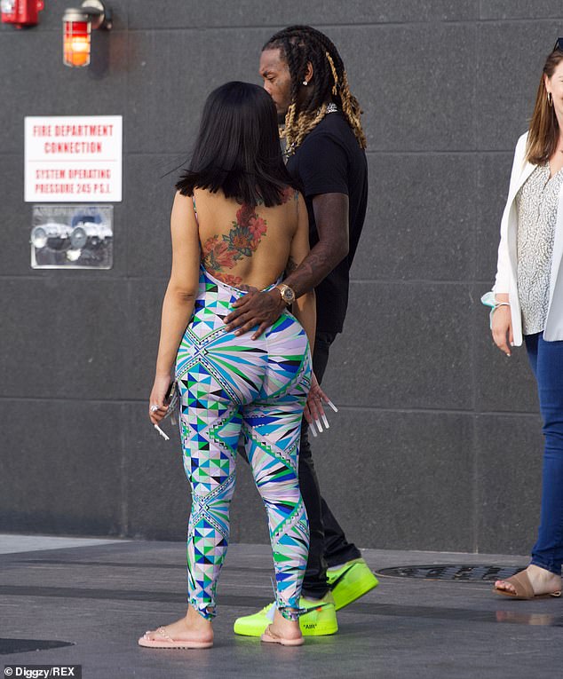 Fashion forward: Bright shades of green, blue and grey were intertwined into a graphic print on the one-piece outfit which featured a low back for Cardi to show off her arsenal of tattoos