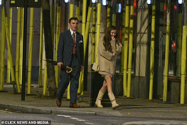 Beauty: Meanwhile, his female companion looked stylish as she wrapped up in a stone jacket, which she paired with shin-high matching boots and a white mini skirt