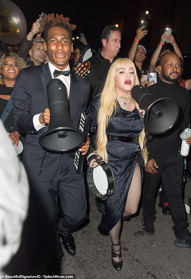 Marching orders: After their midnight show at Harlem restaurant the Lucky Star singer took the streets and lead singing fans down the street