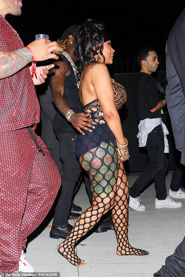 Daring display: The WAP hitmaker donned a pair of black fishnet tights which left her elaborate body art visible on her leg through the gaps in the material