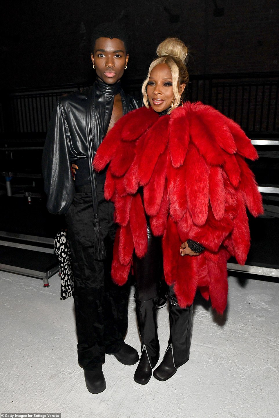 Fashion forward: Mary ensured she caught the eye of onlookers in her unique coat which she teamed with a pair of black leather trousers with silver zips to the front as she posed with model Alton Mason, 23, at the fashion show