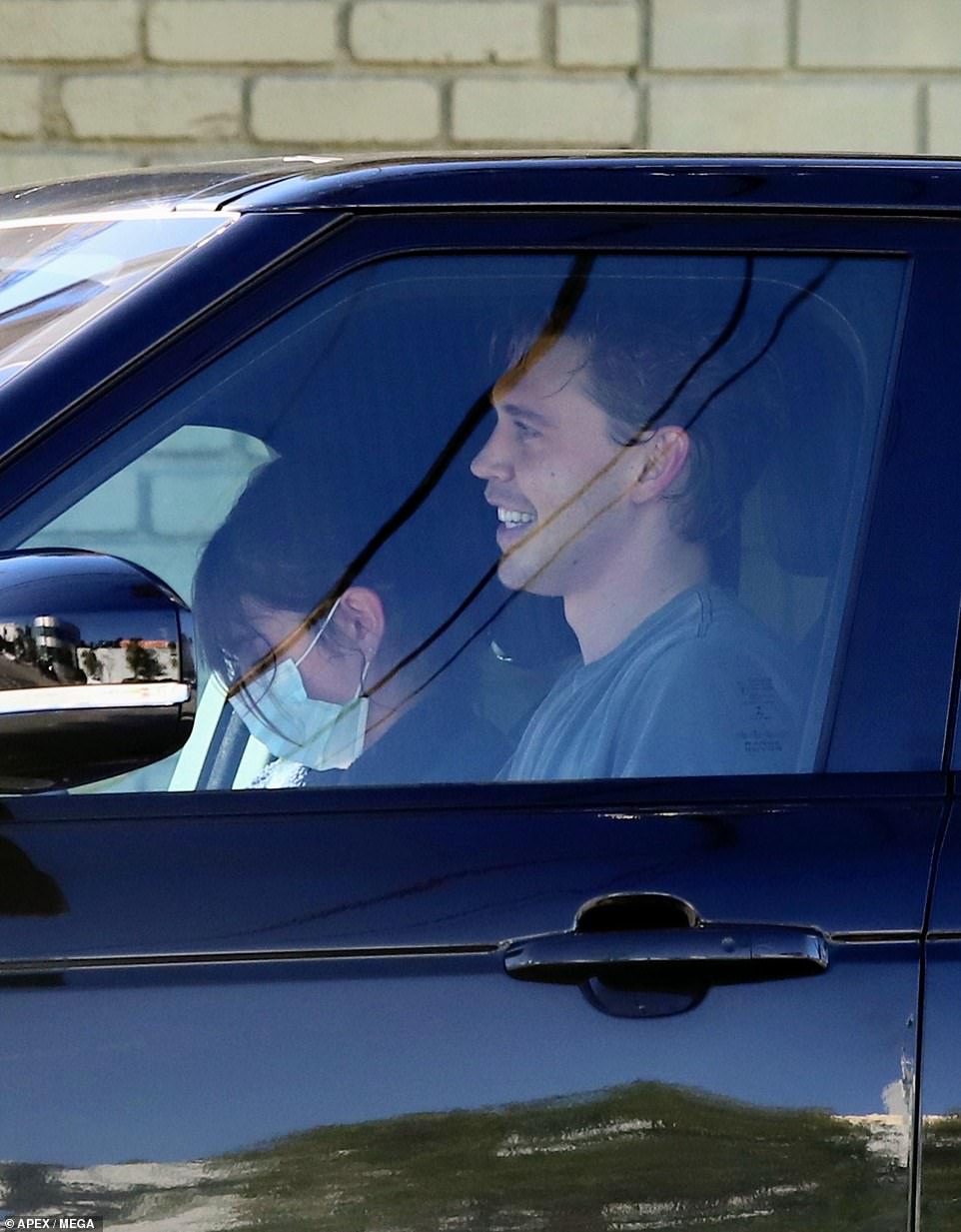 Ready to hit the road! Butler removed his face mask as he hopped into the driver's seat of Kaia's car