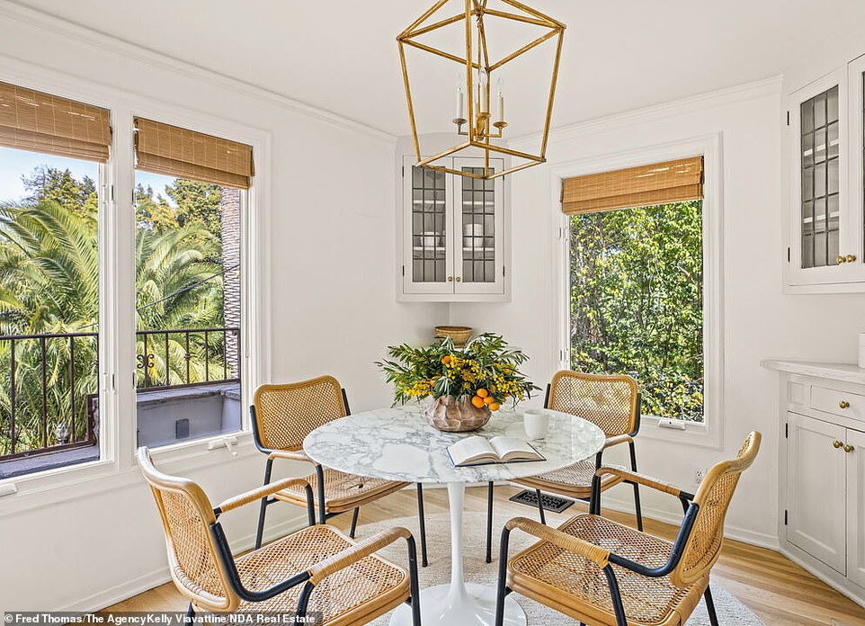 That entrance opens into a tiled foyer that includes a wrought-iron staircase and leads into a sunken living room.