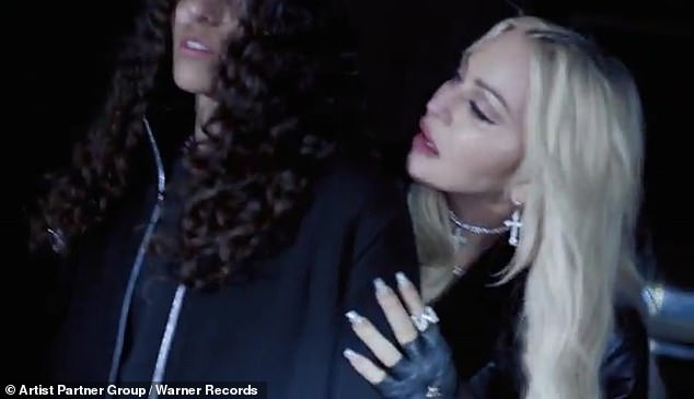 Close contact: Madonna (born Madonna Ciccone) stays close to her collaborator throughout the video, which never varies from the gray warehouse setting. She rests her head on the rapper's shoulder at one point and runs her hand up her arm suggestively