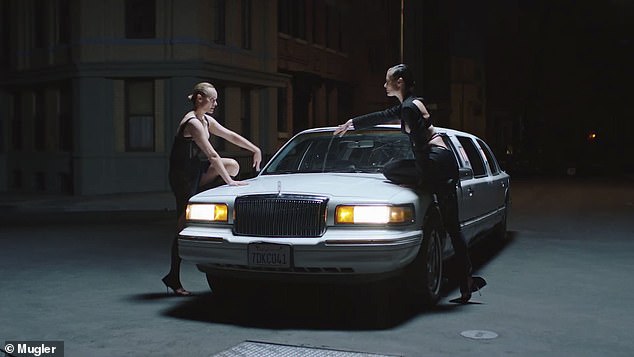 Before the kiss: The ladies stared each other down before climbing on the hood of the car