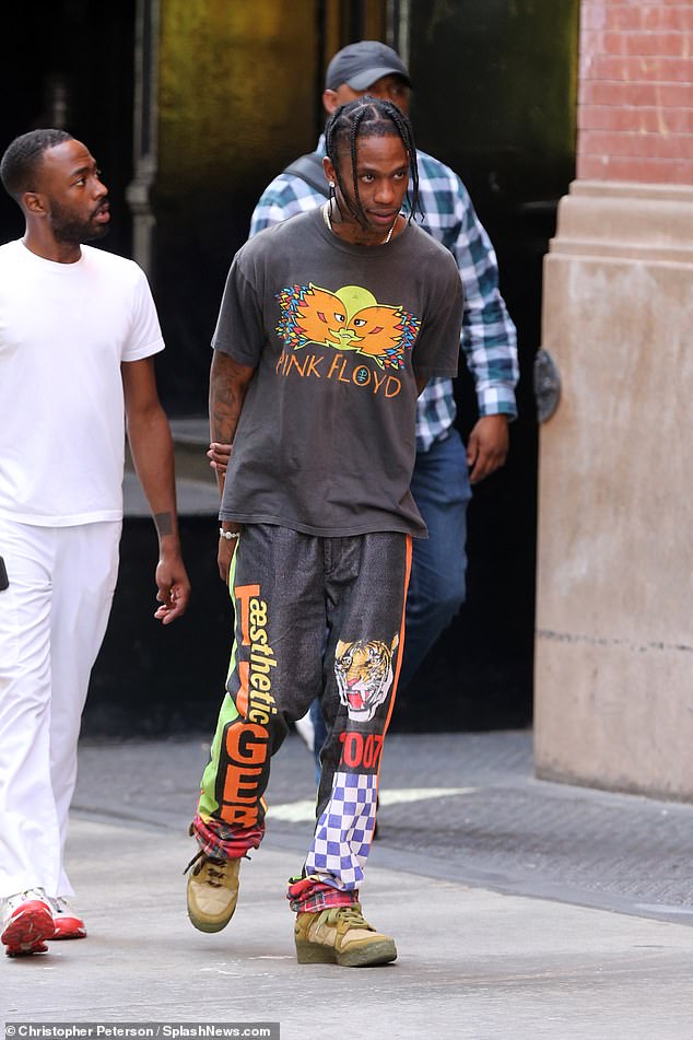 Day off: Travis Scott rocked a light grey Pink Floyd band t-shirt and an eccentric pair of pants, featuring a tiger graphic and checkerboard pattern, while out in New York City