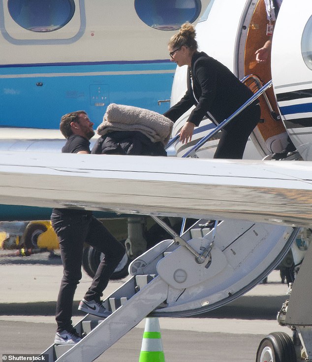 Long haul: A team of assistants were seen carrying her things on board