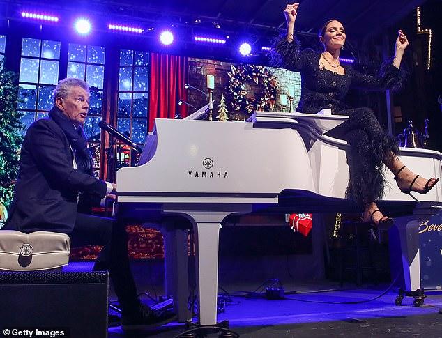 Looking fab: Throwing herself into the spirit of the season, Katharine hopped on top of her husband's white Yamaha piano and crossed her dancer's legs