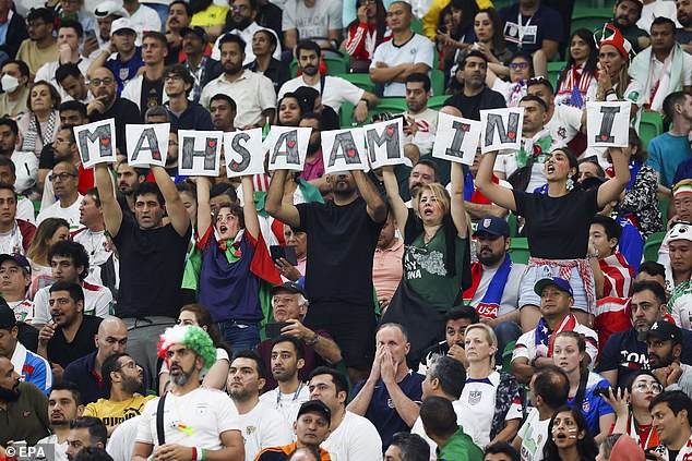 Iranian supporters show signs with the name Mahsa Amini during the final group B match between the US and Iran on Tuesday