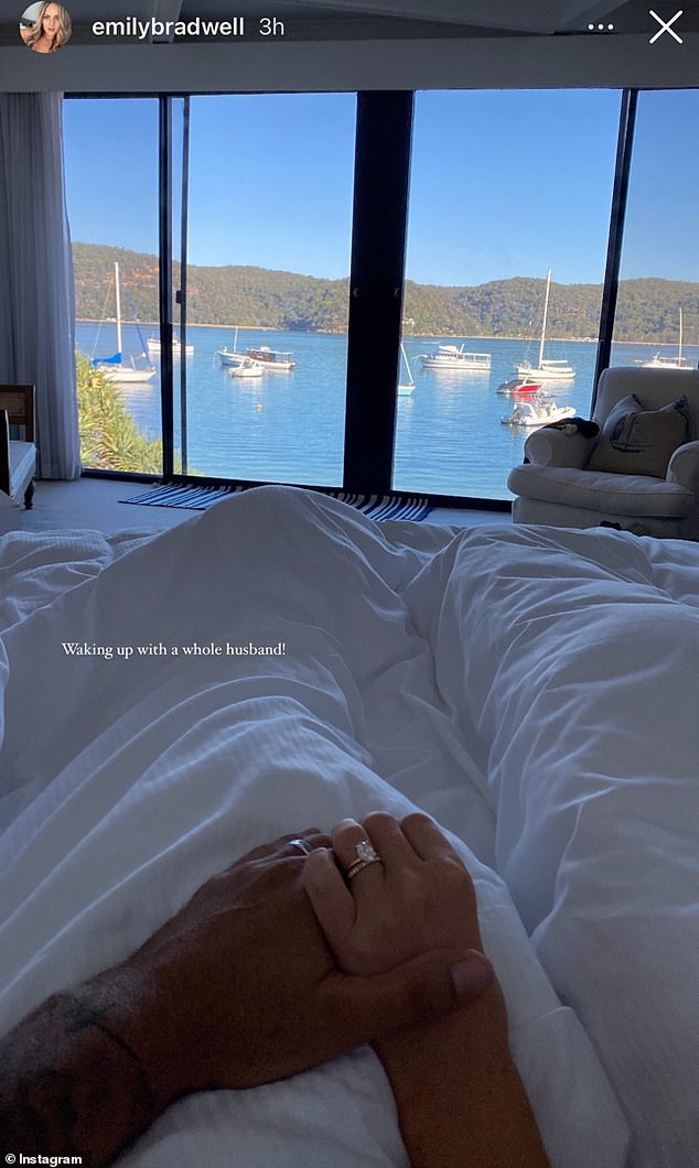 Emily shared a picture of herself holding hands with Carlin in bed overlooking Pittwater after their wedding on Friday, as the pair showed off their wedding rings