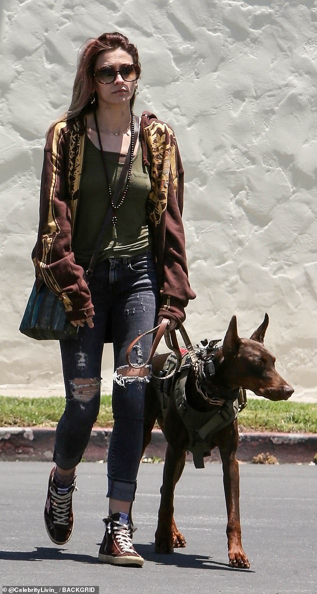 Stylin': The Beverly Hills native stepped out in dark blue skinny jeans with holes on both knees and a brown and tan-patterned jacket over a black t-shirt