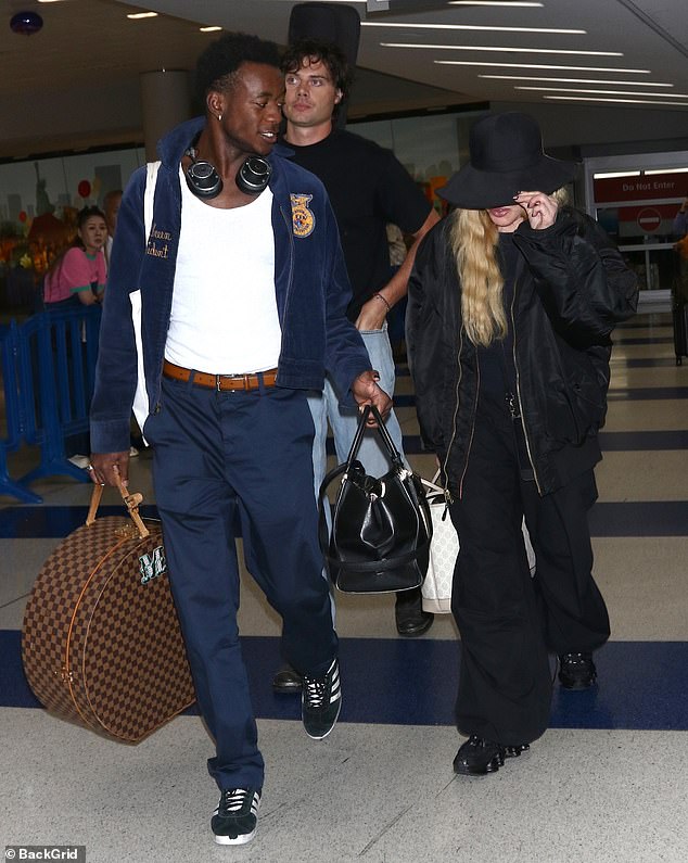 Good company: The songwriter, who recently introduced her 29-year-old boyfriend to one of her kids, was also joined by her son David, 17, as she made her way through the airport's busy walkways