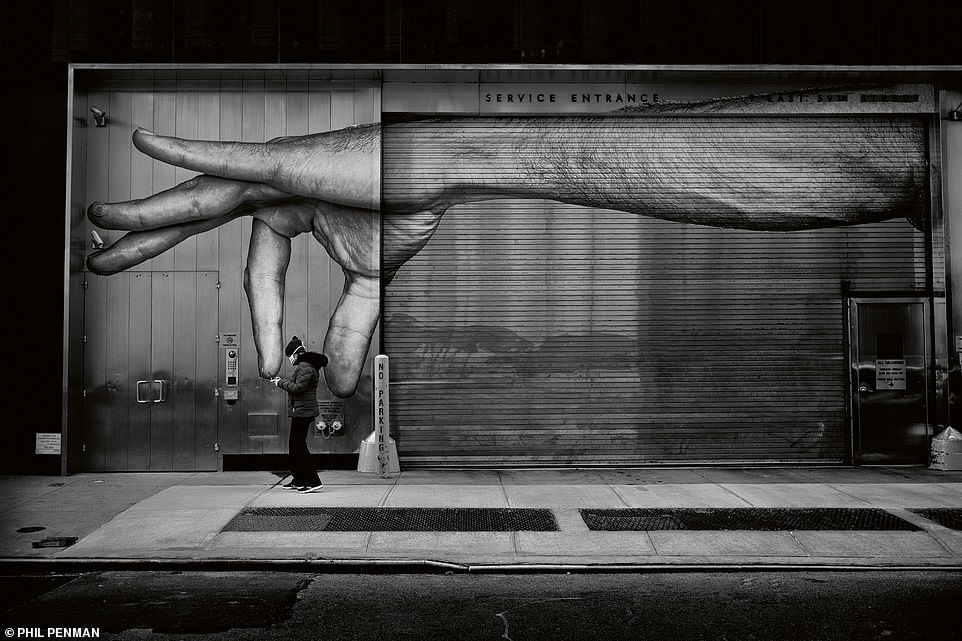 A masked person walks past a street mural in midtown in March, 2020