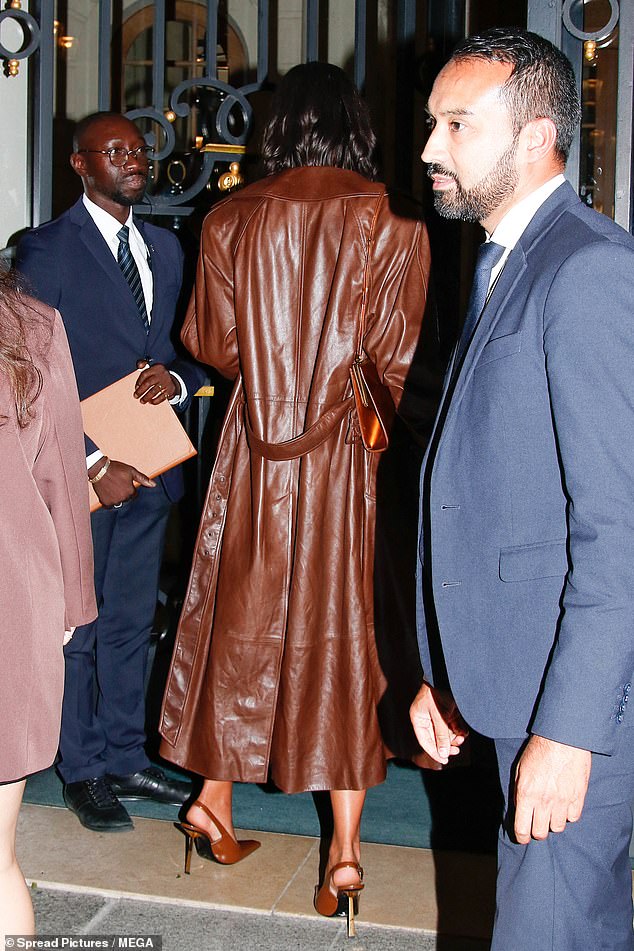 Striking in leather: Draped over the outfit was an oversized, three-quarter length chocolate brown leather jacket, teamed with leather pumps with gold-plated geometric stiletto heels