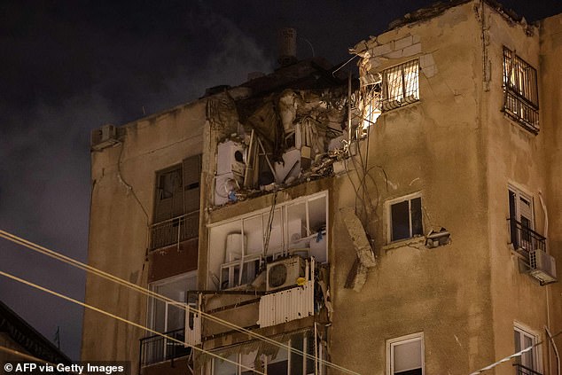 A building in Tel Aviv is damaged by a rocket fired by Palestinian militants from the Gaza Strip on October 7