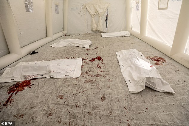 Covered bodies of dead Palestinians lie on the floor at the Al-Shifa hospital after an Israeli air strike in Gaza City, 09 October 2023