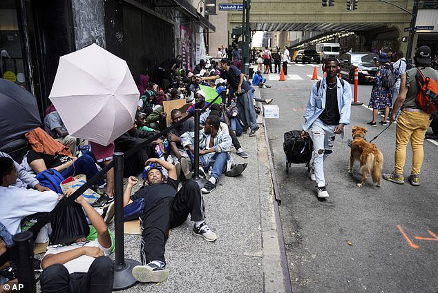 A surge in arrivals has caused New York to say that it is full, directing migrants to go elsewhere. This file photograph shows people waiting outside the Roosevelt hotel for beds