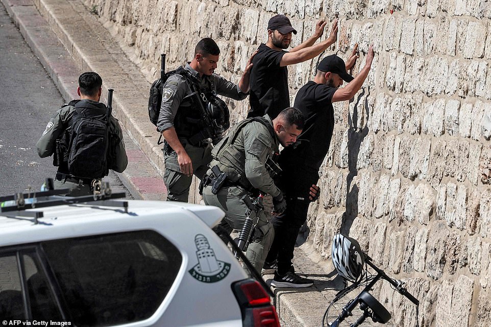 Israeli border guards and police search Palestinian youths outside the Lion's gate of the Old City of Jerusalem on Friday