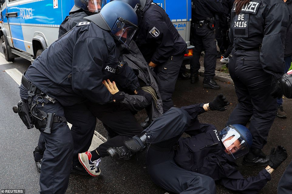 GERMANY: A Pro-Palestinian demonstrator is detained while a police officer is thrown to the ground at a protest during the ongoing conflict between Israel and the Palestinian terrorist group Hamas in Berlin on Friday